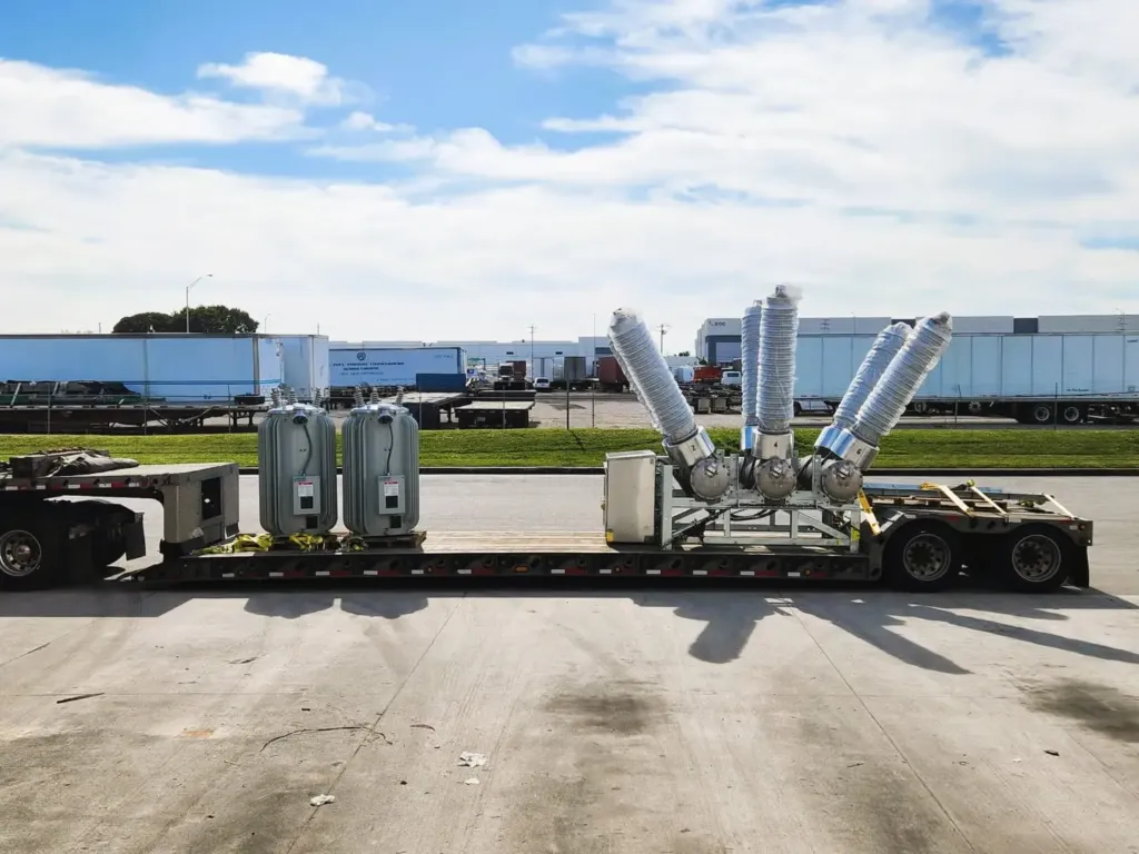 Industrial generator sets loaded on a flatbed trailer outside the Miami warehouse.