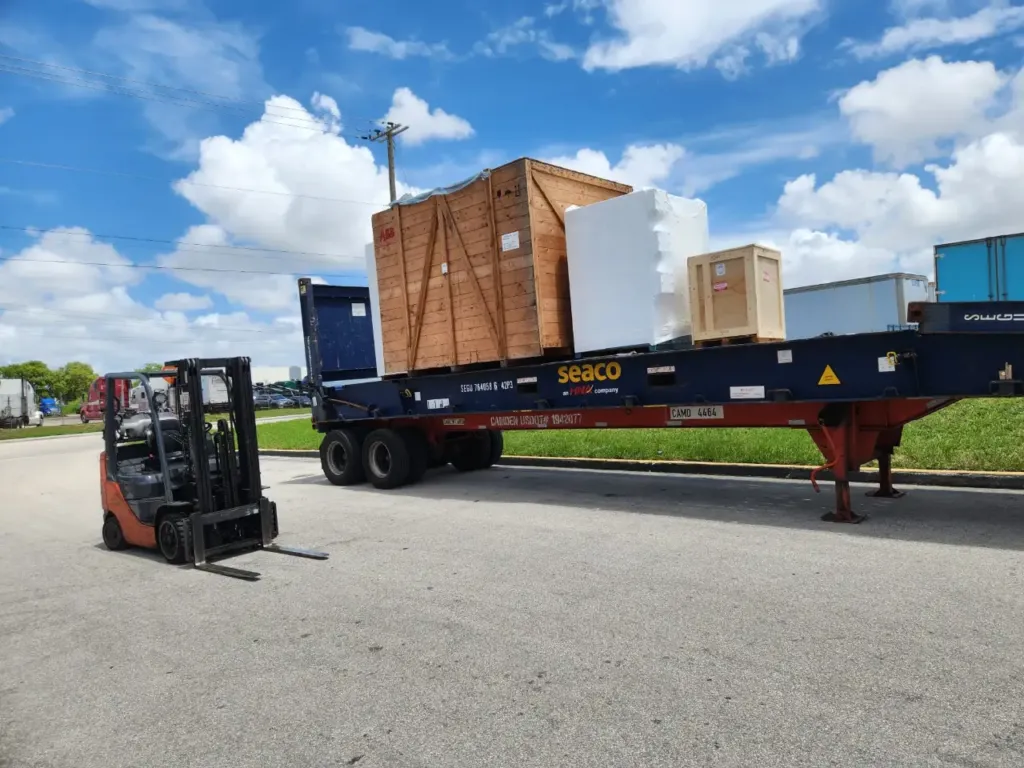 Crated cargo loaded onto a flat rack container by forklift at the Miami facility