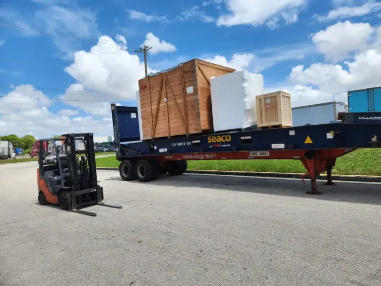 Crated oversize cargo strapped and secured on a flat rack trailer