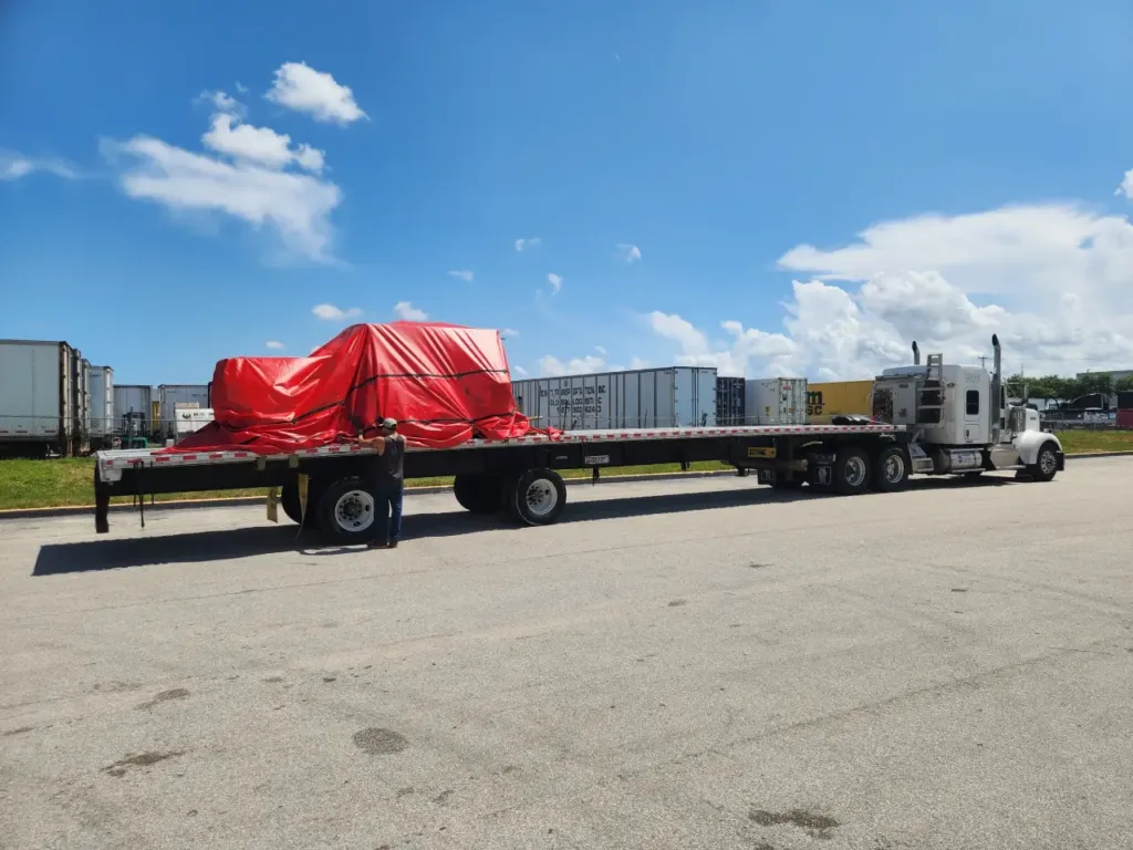 Oversize cargo tarped and strapped on a flatbed trailer at the Miami facility.