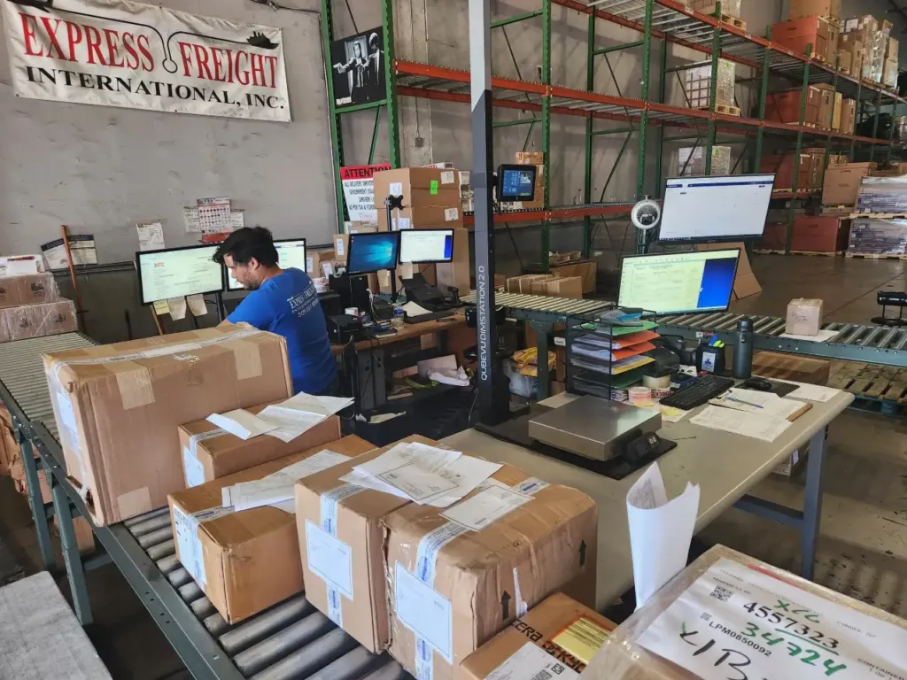 EFI staff working at the receiving and cargo dimensioning station in the Miami warehouse.