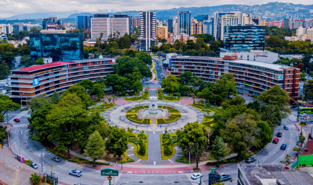 Aerial view of Plaza España in Zona 9, Guatemala City, with office towers behind the fountain roundabout